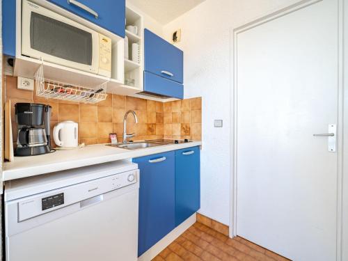 - une cuisine avec des placards bleus et un four micro-ondes dans l'établissement Studio pour 4 avec Wi-Fi inclus, vue sur mer à Roquebrune-Cap-Martin - FR-1-827-64, à Roquebrune-Cap-Martin