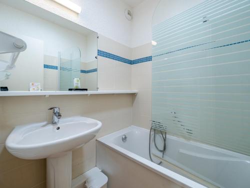 une salle de bain blanche avec un lavabo et une baignoire dans l'établissement Studio 4 personnes avec Wi-Fi illimité à Roquebrune-Cap-Martin - FR-1-827-89, à Roquebrune-Cap-Martin