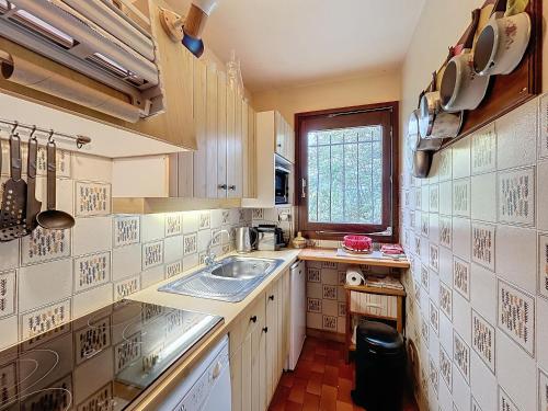 une petite cuisine avec un évier et une fenêtre dans l'établissement Appartement 2 pièces au pied des pistes à Combloux - FR-1-560-162, à Combloux