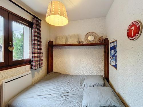 une petite chambre avec un lit et une fenêtre dans l'établissement Appartement 2 pièces au pied des pistes à Combloux - FR-1-560-162, à Combloux