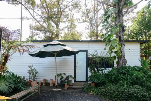a house with an umbrella in the yard at Dancasa Horse Farm & Homestay in Buôn Chiêt