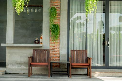 two chairs and a table in front of a building at Kampot Sweet Boutique in Kampot