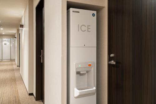 a door with an ice machine in a hallway at Hotel Oriental Express Kagoshima Tenmonkan in Kagoshima