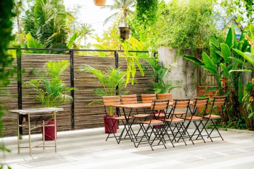 a patio with a table and chairs in a garden at Kampot Sweet Boutique in Kampot