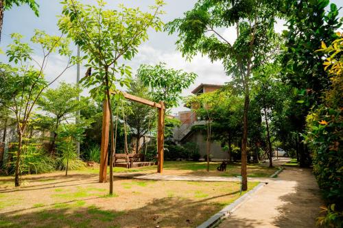 a park with trees and a swing at Kampot Sweet Boutique in Kampot