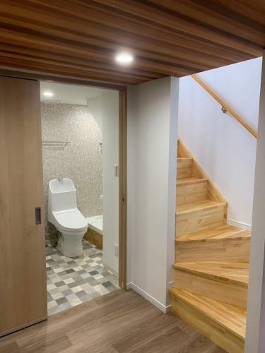 a bathroom with a toilet and stairs in a room at 寬居 kuanju 一棟貸し 広々一戸建て JR桜ノ宮駅徒歩3分 最大8名 梅田 大阪城公園アクセス良好 in Osaka