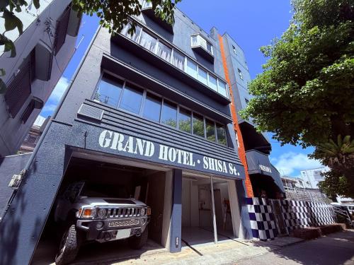 a jeep parked in a garage in front of a building at GRAND HOTEL SHISA St OKINAWA グランドホテル シーサーストリート沖縄 in Urazoe
