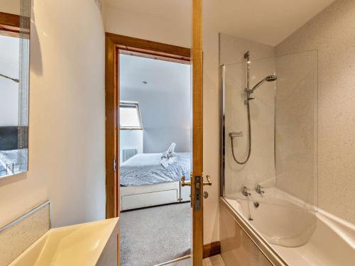 a bathroom with a shower and a tub and a bed at 3 Bed in Fairbourne 77304 in Arthog