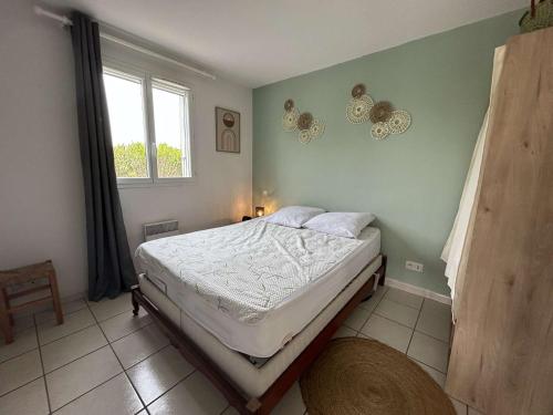 une chambre avec un lit dans une pièce avec une fenêtre dans l'établissement Maison climatisée avec 2 pièces et mezzanine, 5 couchages, parking, St Pierre la Mer - FR-1-229D-159, à Fleury