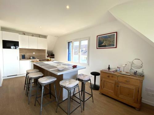 une cuisine avec un îlot et des tabourets de bar dans l'établissement Bel appartement rénové avec vue mer à Trégastel, proche plage - FR-1-368-462, à Trégastel