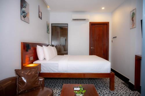 a hotel room with a bed and a chair at Kampot Sweet Boutique in Kampot