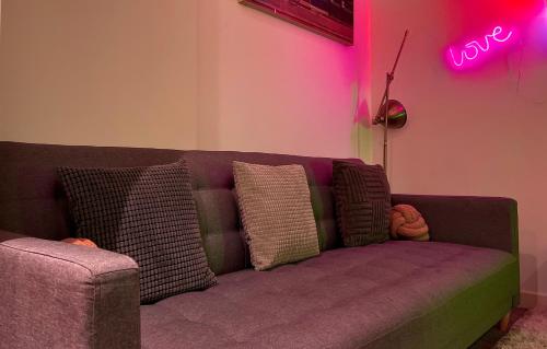 a purple couch in a room with a neon sign at Chic, Central Haven, Games, Balcony Zen, 2BR in Midland