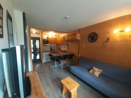 Cette chambre comprend un lit, une table et une horloge. dans l'établissement Studio cabine cosy pour 4 pers à Valfréjus - FR-1-561-140, à Modane