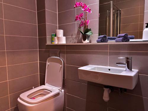 a bathroom with a pink toilet and a sink at Chic, Central Haven, Games, Balcony Zen, 2BR in Midland