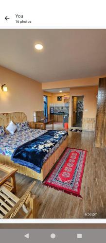 Un dormitorio con una cama grande y una alfombra. en Apple Orchards 1Bhk With Kitchen, en Manali