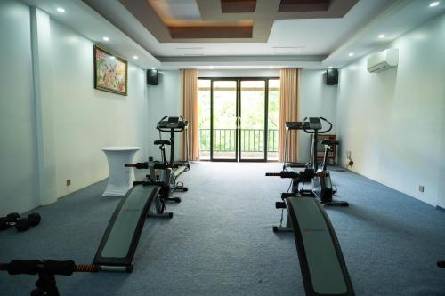 a gym with several treadmills and machines in a room at Kampot Sweet Boutique in Kampot