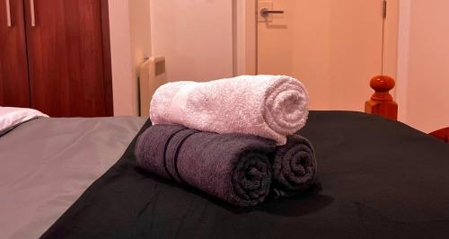 a pile of towels sitting on top of a bed at Chic, Central Haven, Games, Balcony Zen, 2BR in Midland
