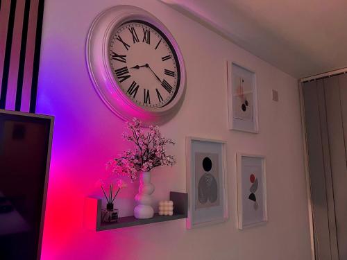 a clock on a wall with a purple light at Chic, Central Haven, Games, Balcony Zen, 2BR in Midland
