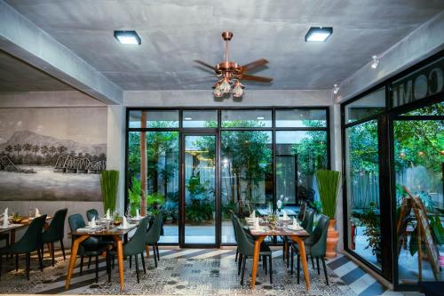 a dining room with tables and chairs and a ceiling fan at Kampot Sweet Boutique in Kampot