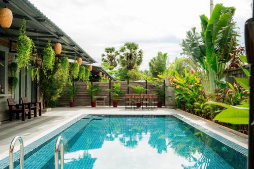 a swimming pool in a backyard with plants at Kampot Sweet Boutique in Kampot