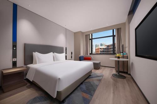 a hotel room with a large bed and a tv at Holiday Inn Express Qingdao City Balcony by IHG in Qingdao