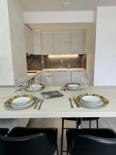 une cuisine avec une table avec des assiettes et des verres à vin dans l'établissement L'orée du lac tout confort 3 garage privatif, au Bourget-du-Lac