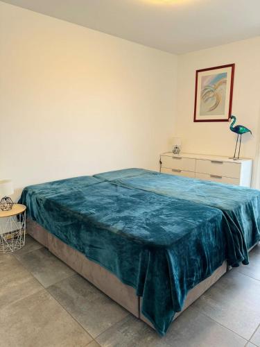 une chambre avec un grand lit avec une couverture bleue dans l'établissement L'orée du lac tout confort 3 garage privatif, au Bourget-du-Lac