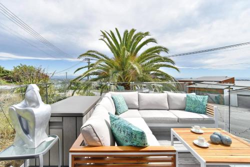 a living room with a white couch on a balcony at Mount Pleasant - Ocean Views - 3 bedroom with bathtub in Christchurch