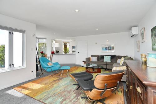 a living room with blue chairs and a couch at Mount Pleasant - Ocean Views - 3 bedroom with bathtub in Christchurch
