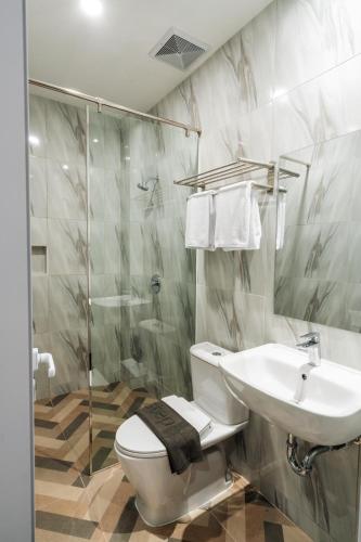 a bathroom with a toilet and a sink and a shower at Stay Kertapati Hotel in Kertapati