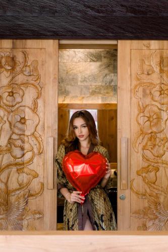 a woman holding a red heart in a doorway at Villa Dijabu in Kuta