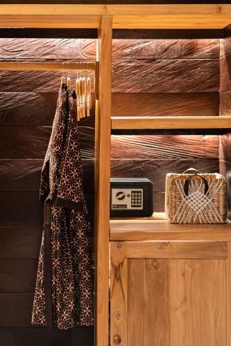 a shelf with a clock and a towel on it at Villa Dijabu in Kuta