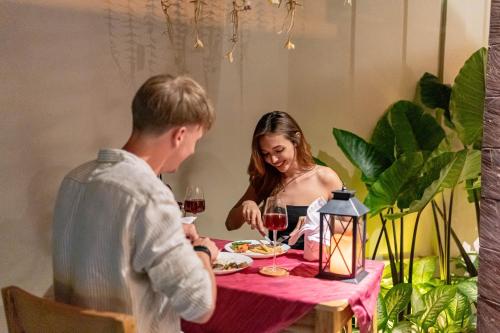 a man and a woman sitting at a table with wine glasses at Villa Dijabu in Kuta
