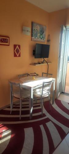 a dining room table with two chairs and a computer monitor at Nido Dei Gabbiani in Magliolo