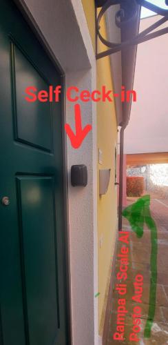 a door with a red exit sign next to a wall at Nido Dei Gabbiani in Magliolo