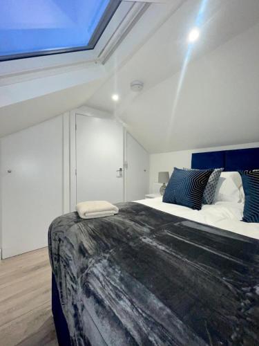 Un dormitorio con una cama grande y una claraboya. en Trinity Apartments - 2 Bed Apartment - sleeps 6 - Spacious - Modern - 30 Seconds from High Street, en Huntingdon