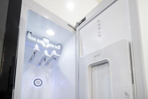a room with a white refrigerator and some bells at Comport Hotel in Pohang