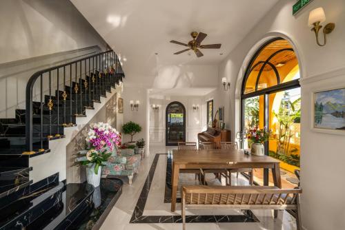 a dining room with a table and a staircase at Naraco Homestay Hoi An in Cam Thanh