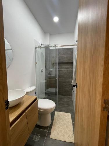 a bathroom with a toilet and a glass shower at Cozy apartment in Apartadó in Apartadó