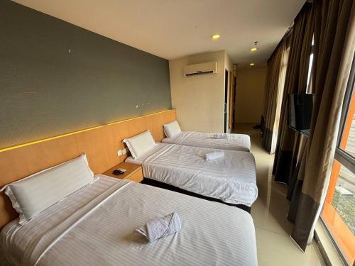 a hotel room with two beds and a flat screen tv at Signature Hotel by Easy Nap in Puchong