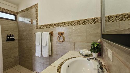 a bathroom with a sink and a shower and a tub at Casa Macaw Jungle Cabin w Private pool Wifi and AC in Quepos
