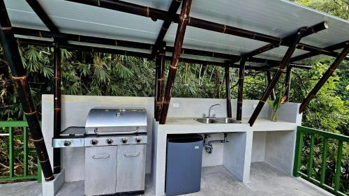 a outdoor kitchen with a sink and a stove at Casa Macaw Jungle Cabin w Private pool Wifi and AC in Quepos