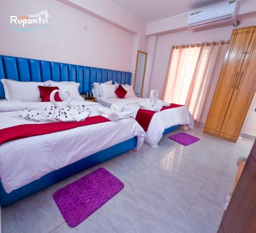two beds in a room with purple rugs at Hotel Ruponti in Kuākāta