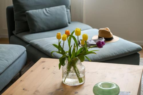 a vase of flowers on a table in a living room at Homey & Spacious 2BR Apt in the Heart of Tel-Aviv by Sea N' Rent in Tel Aviv
