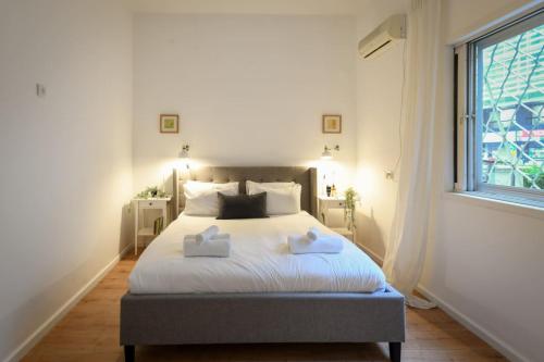 a bedroom with a bed with two towels on it at Homey & Spacious 2BR Apt in the Heart of Tel-Aviv by Sea N' Rent in Tel Aviv