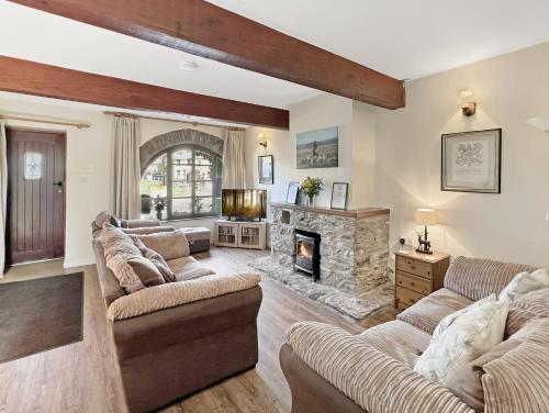 a living room with two couches and a fireplace at The Old Forge in Exford