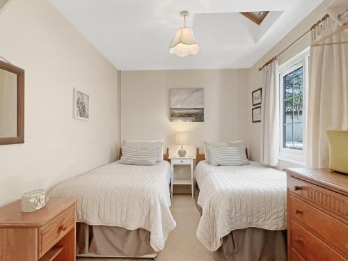 a bedroom with two beds and a window at The Old Forge in Exford