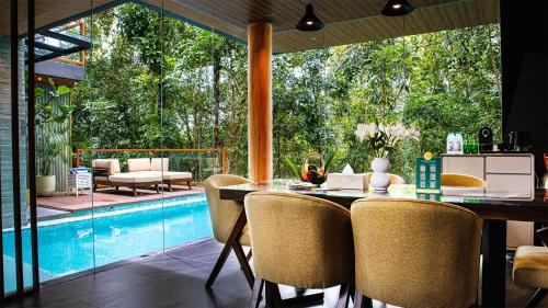 a dining room with a table and a swimming pool at House of Gaia in Lipa