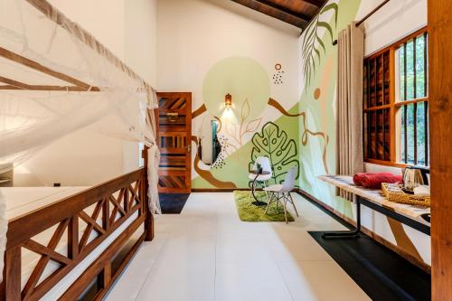 a room with a bed and a mural on the wall at Artisan By Sebu in Galle