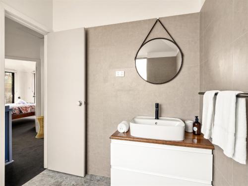 a bathroom with a sink and a mirror on the wall at Cosy Corner Town Centre in Margaret River Town
